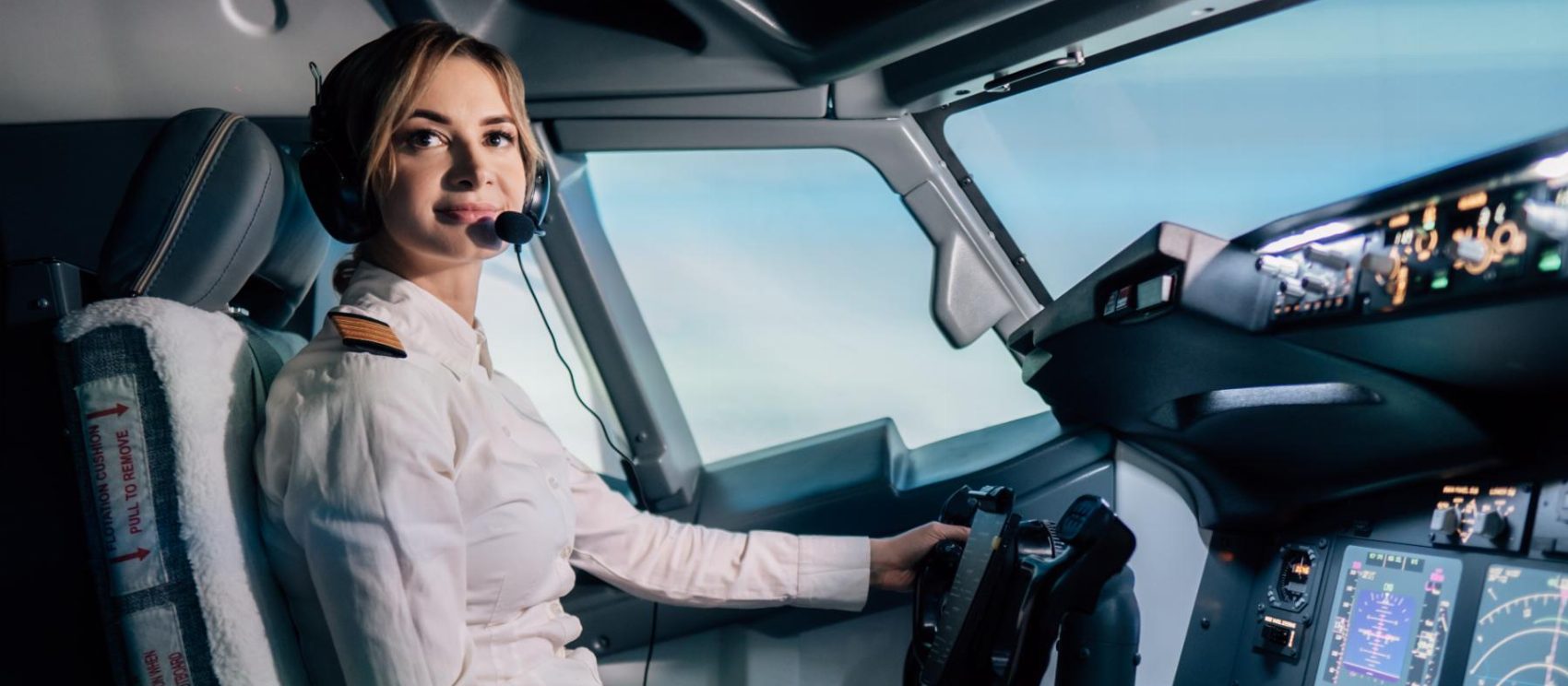 A pilot at the controls of a full flight simulator